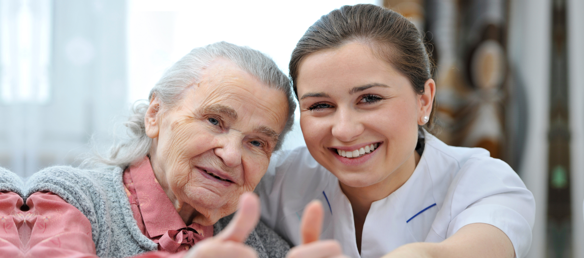 senior woman and young woman smiling while thumbs up