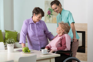 Two aged women and young nurse spending together happy afternoon