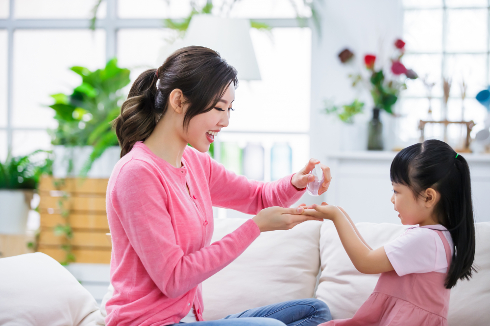 Mom teach child wash hands with sanitizer alcohol