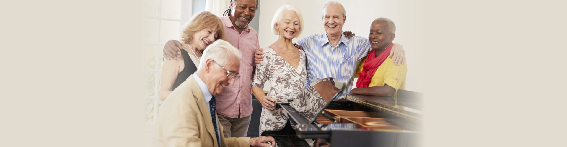 Group Of Seniors Standing By Piano And Singing Together