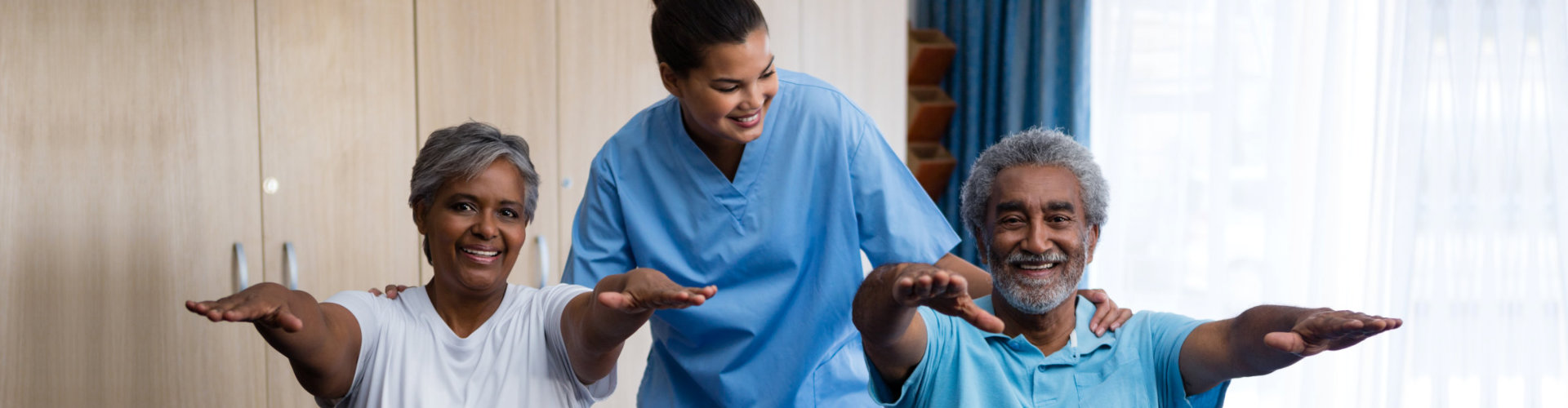 Nurse guiding seniors in exercising at retirement home