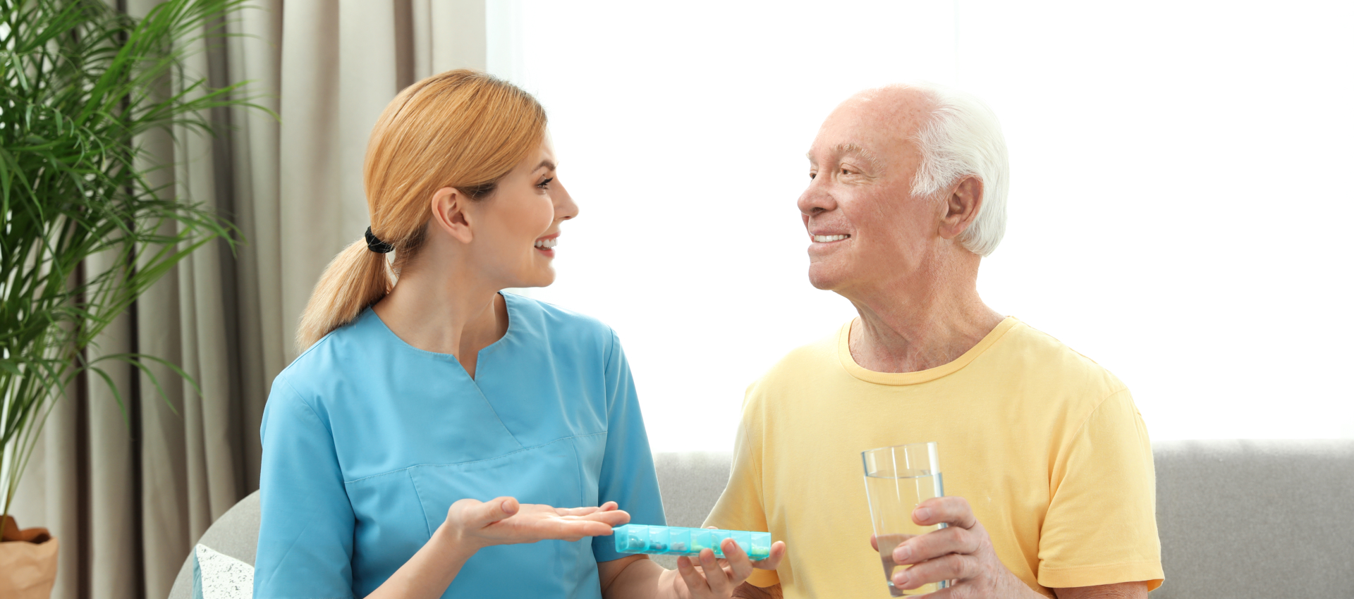 woman giving medicine to senior man